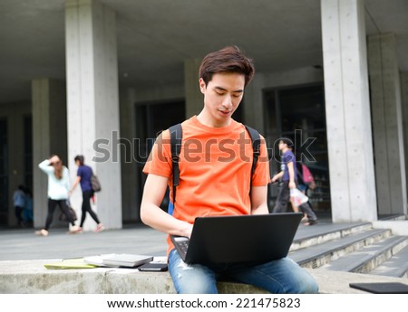 Portrait of Asian student sitting use laptop at campus