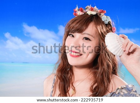 Young woman holding shell at the ocean,