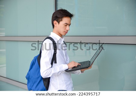 Casual male student with bag and laptop