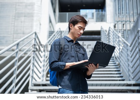 portrait of male college student use laptop at campus