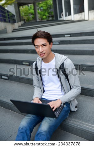 Casual male student with bag use laptop