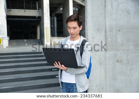 male college student use laptop at campus