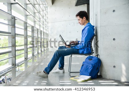 asian college student sitting student with laptop on campus