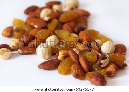 A handful of trail mix of almonds, hazelnuts, and raisins