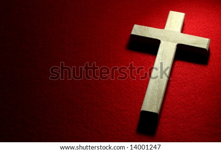 Closeup of wood crucifix on red felt background.