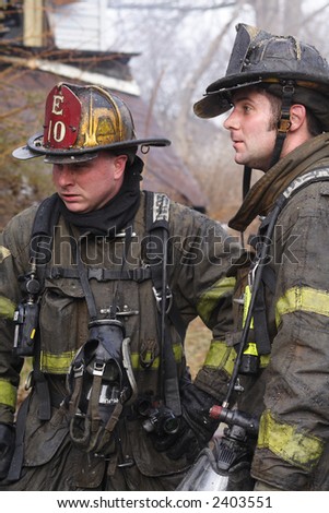 Two Fireman having a discussion while on the job at a fire