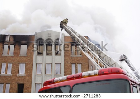 View from the truck of a fireman up on top of the ladder