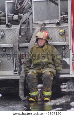 Old Fireman sitting on the back of the fire truck