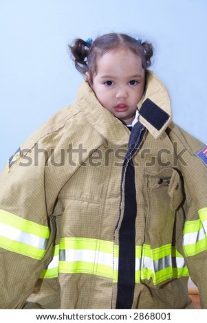 Adorable toddler in a big fireman\'s coat