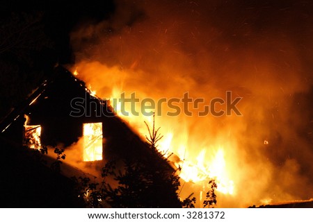 The upper floor of an urban house on fire in the night
