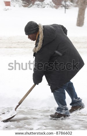 Young black man shoveling the walk in a winter storm