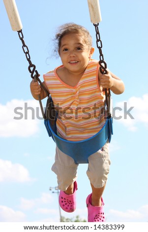Little girl enjoying herself swinging on a sunny summer day A toddler girl crying and covering her face