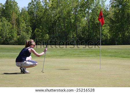 college aged girl surveying her putt on the last hole