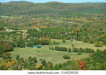 October Color surrounds Farm house and barn in a White River valley in Ozark Mountains from Overlook in Northern Arkansas.