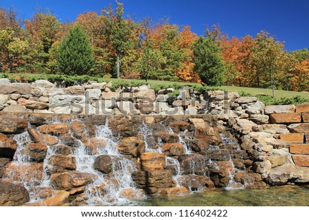 Water Feature outside The Lodge at Mount Magazine in Mount Magazine State Park in Arkansas Ozarks in October with brightly colored Fall Trees in background and deep blue sky.