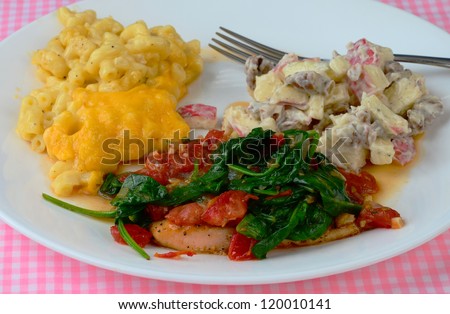 Special spinach and tomato sauce with onions and garlic over salmon and served with macaroni and cheese and apple salad.