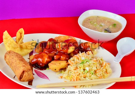 Sweet and Sour Chicken Chinese Dinner with fried rice, egg roll and Crab Rangoon on colorful red and purple background.  Served with Hot and Sour Soup.