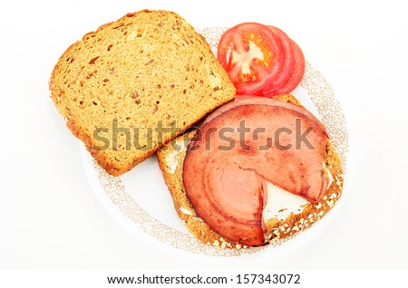 Fried bologna on 12-grain, whole grain, bread with sliced tomato and mayonnaise.