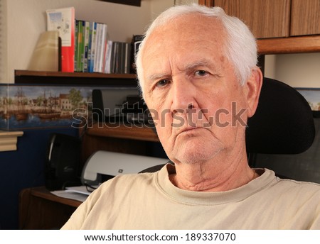 Senior man in casual clothes and needing a shave working from the comfort of his home office.
