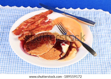 Blueberry syrup and butter on whole wheat pancakes with bacon and fruit.  Whole wheat is high in antioxidants.