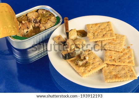 Snacking on Smoked Herring packed in soy bean sauce with green chile peppers and served on saltine crackers.