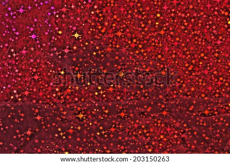 Colorful starry sky background made from wrapping paper with bright red, yellow, purple stars.