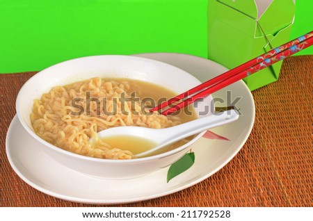 Bowl of Ramen Noodle Soup in Chinese dishes with take out carton in background.