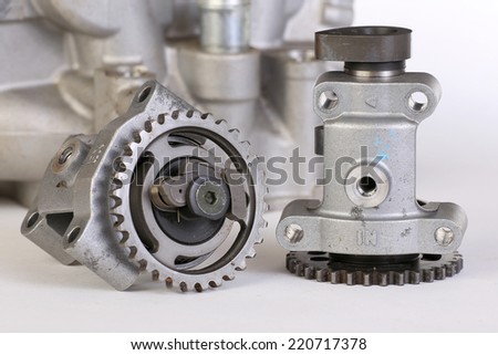 Damaged camshafts from twin overhead cam racing motorcycle engine with cylinder in background.  Exhaust and Intake Cams on white background.