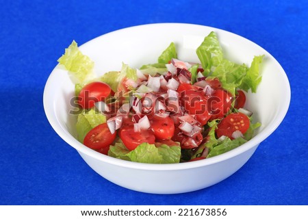 Tart Raspberry Walnut Vinaigrette dressing on crisp garden salad of cherry tomatoes, onions and Romaine Lettuce.