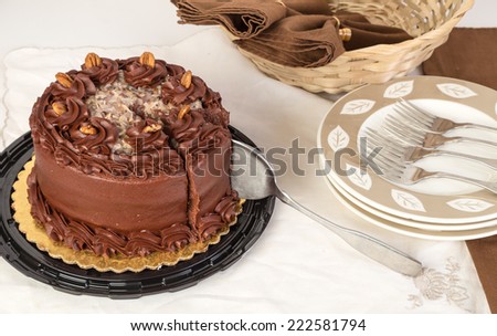 German Chocolate Cake in elegant setting with cake knife cutting a piece.