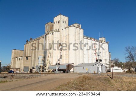 Silos and elevators for storage and distribution at large processing facility in Arkansas Rich Rice Growing area.  Railroad for transporting finished product in foreground.
