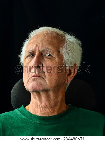 Scruffy Gray haired senior man with questioning expression on face.  Vertical Head and shoulders  against black background with copy space.