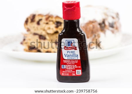 LLANO, TEXAS-DEC 24, 2014:  Small bottle of McCormick Pure Vanilla Extract with baked cake in background.  Horizontal with copy space.