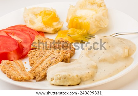 Soul Food breakfast of milk gravy on biscuits flavored with fried salt pork.  Served with sliced tomatoes and lemon curd spread on buttered biscuit.