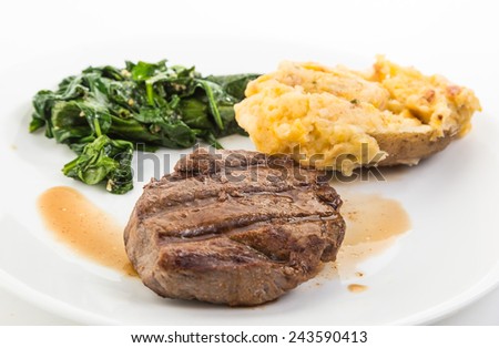 Steak beautifully grilled with deep grill marks on plate with its own juice (au jus) and served with \