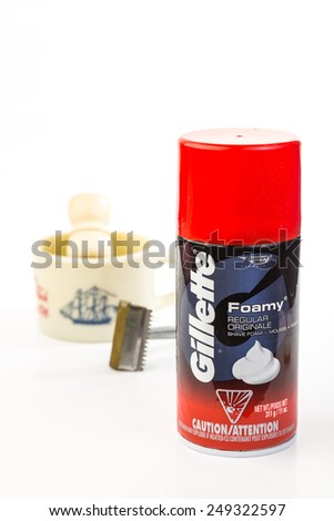 LLANO, TEXAS-FEB 02, 2015:  Aerosol can of Gillette Foamy Instant Shaving Lather juxtaposed on antique safety razor and vintage shaving mug with brush.  White background with copy space.