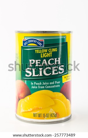LLANO, TEXAS-MAR 03, 2015:  House Brand of canned Peach Slices in Peach Juice and Pear Juice from Concentrate.  Vertical against white background with copy space.