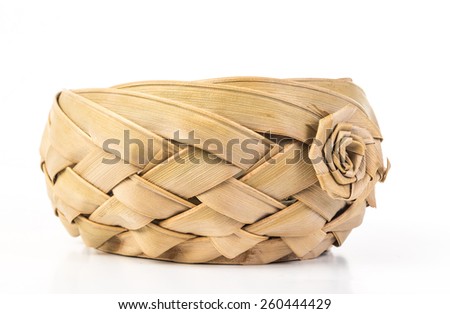 Old fashioned woven wicker basket weaved with thick bark strips with crafted flower decoration.  White background with copy space.