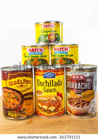 LLANO, TEX-MAR 24, 2015:  Cans of Mexican  Food on white background with copy space.  Enchilada; refried beans; borracho beans; chile peppers; jalapenos; spices and sauces.