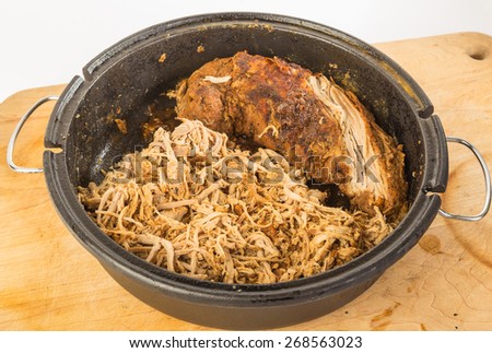 Making Pulled Pork Barbecue in Dutch Oven.  Two slabs of pork tenderloin - one already shredded or \