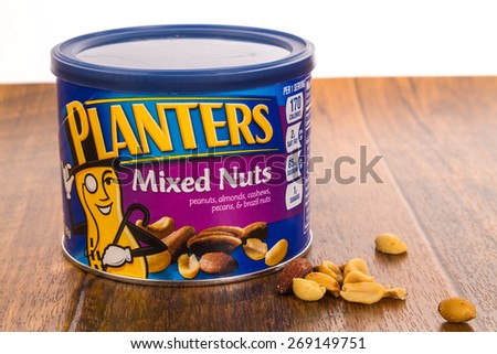 LLANO, TEXAS-APR 12, 2015:  Planters Mixed Nuts on rustic wooden surface with white background.  A favorite salty snack.