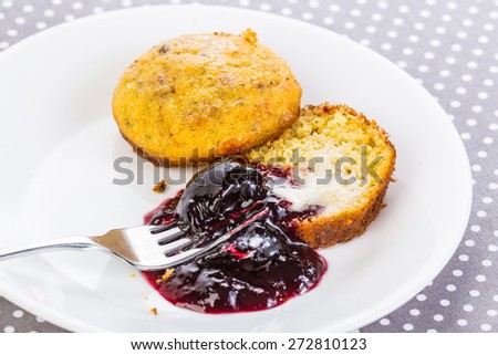 Seedless blackberry jam on white plate with buttered cornbread muffin.  Traditional Soul Food dessert.