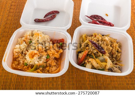 Two styrofoam boxes of leftovers meals from Thai Restaurant.  Sweet and Sour Chicken and Phad Thai -- Thai Stir Fry.