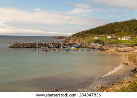 Fishing fleet moored in quiet harbor of White Point, a small fishing village of Cape Breton Nova Scotia Canada.  Colorful boats calm water.