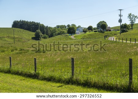 Dairy farm in rolling hills of Appalachian Mountains in Virginia with cattle grazing in background.
