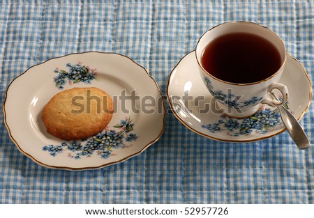 Tea and Cookies country style.  Served on gold-trimmed country china with floral and grape design, setting on blue gingham placemat.