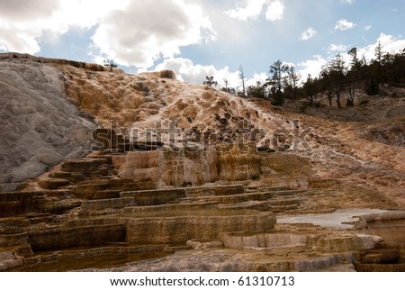 Hot flowing water carries minerals, chemicals and bacteria that over eons form the fantasy land formations that is Mammoth Hot Springs landscape in Yellowstone National Park.