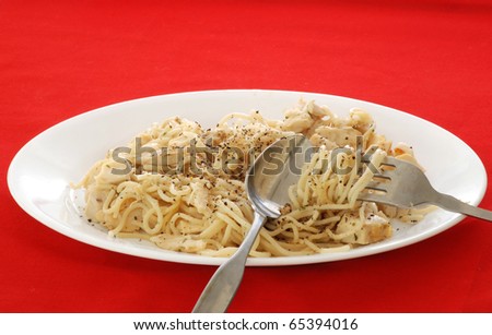 Closeup of Chicken Pasta dish on white plate against white background.