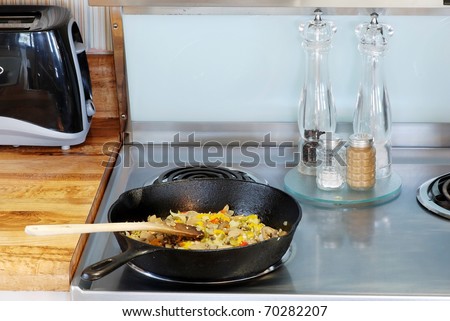 Assorted vegetables sauteing in old iron skillet in preparation for inclusion in a main dish.