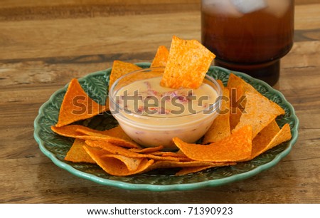 Pimento, peppers and cheese dip served with tortilla chips and mixed drink on bar as Happy Hour Snacks.